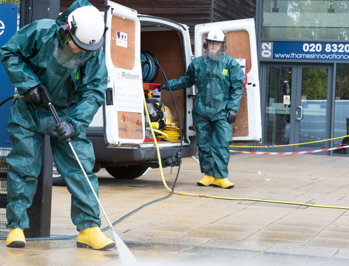 Workers water jetting a pavement